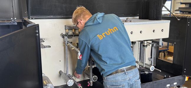 Mitarbeiter bei der Wartung einer Bruhn-Streichmaschine für die industrielle Holzbeschichtung.