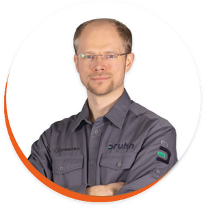 Porträt von Martin Bruhn in einer Kreisgrafik mit weißen Hintergrund. Er trägt ein dunkelgraues Hemd und Brille. Er verschränkt die Arme vor der Brust.